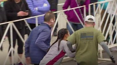 Woman helped by two other runners