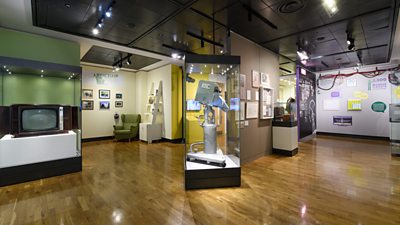 Interior of the Wimbledon Tennis Museum, with various exhibits including an old television camera.