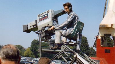 A cameraman with a large 鶹ҳ TV Colour camera on a raised platform