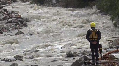 A rescue worker looks at a river