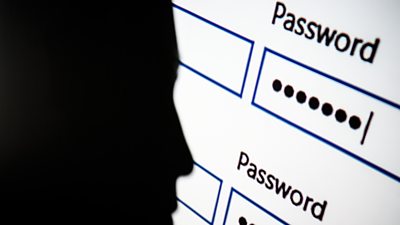 A silhouette of a person next to a password login screen