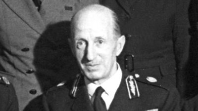 The Earl of Clarendon wearing a military uniform. He has a bald head. 