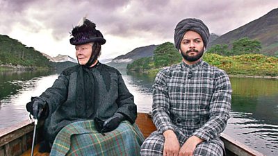 Queen Victoria (Judi Dench) on a boat on a loch with her Indian manservant Abdul (Ali Fazal)