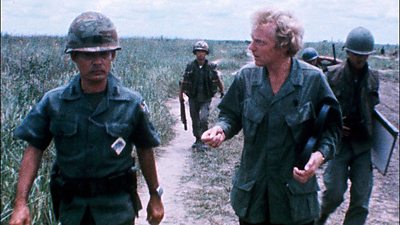 Brian Baron talks to a Vietnamese soldier in the fields 