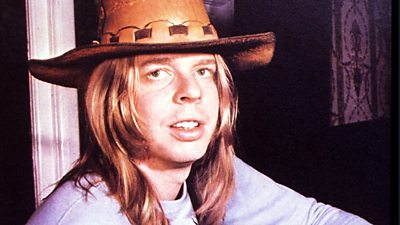 Rick Wakeman with long hair and a large brimmed hat