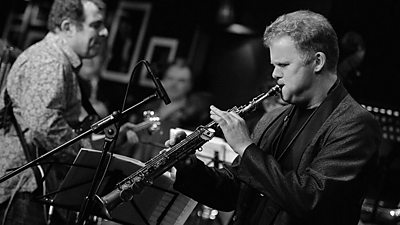 A clarinettist performs with a full orchestra behind