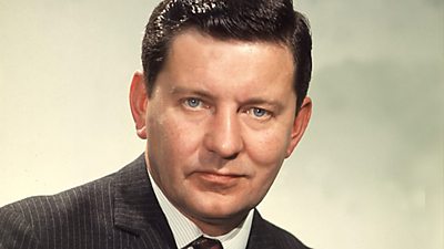 Richard Baker in a photographic portrait in smart pinstriped suit