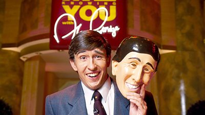 Steve Coogan in character as Alan Partridge holding a mask of Prince Charles