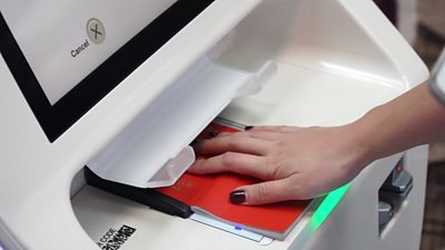 Airline passenger using automated check-in machine