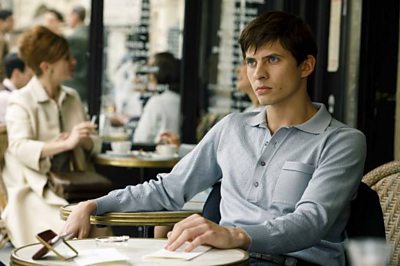 A young man sits nervously at a cafe table