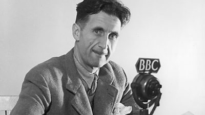 George Orwell at a tv microphone. 