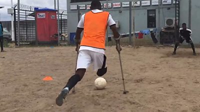 Emmanuel Ibeawuchi on crutches takes a penalty kick