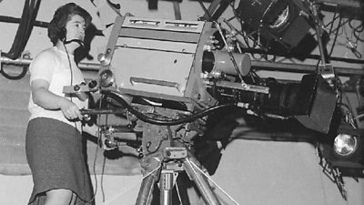 A woman operating a large studio camera