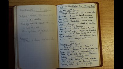 An open diary with blue spidery writing on it.