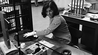 A woman at a film editing station reviews the footage.