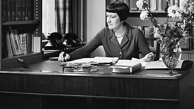 Florence Milnes writes a note at her very tidy desk.