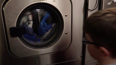 Boy looks at washing machine