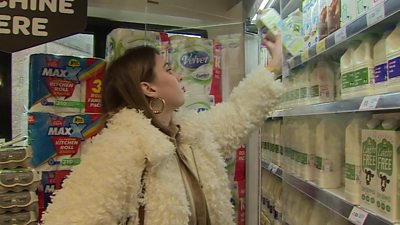Woman choosing non-dairy milk from a shelf