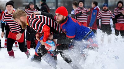 Snow rugby players tackle