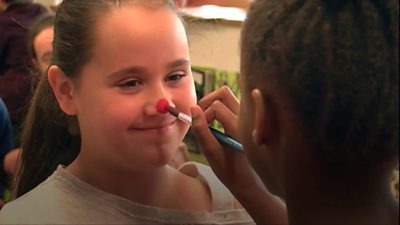 A girl having her nose painted red
