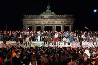 Archive image of Berlin Wall with people sat on it