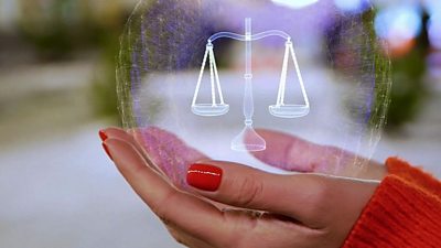 A virtual scales of justice in a woman's hand