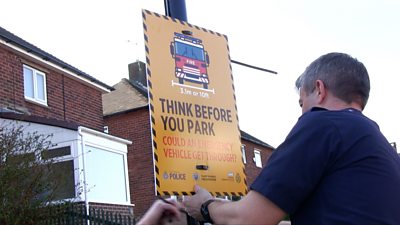 A firefighter installing a sign