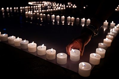 A hand placing candles during Earth hour