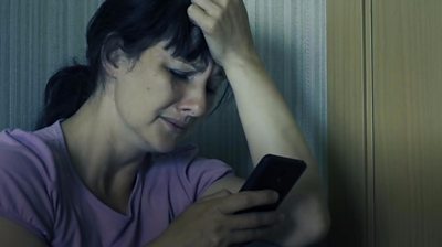 Woman looking distressed with mobile phone