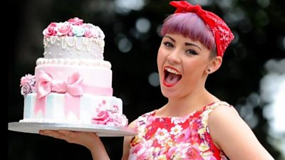 Georgie Rowe holding a cake