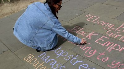 Woman chalking message on pavement