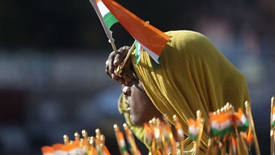 An Indian street vendor sells national flags