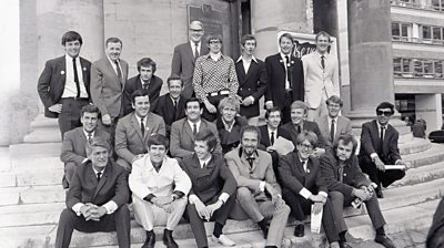 An all-male lineup on the steps of a church in 1967. Most wear smart suit and ties. 