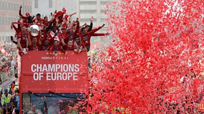 Liverpool"s team bus travels past fans during the parade