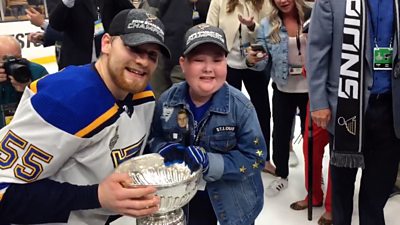 Superfan with Blues player on ice