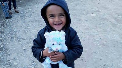 A smiling child with his new teddy