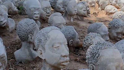 Sculptures of slaves in a field