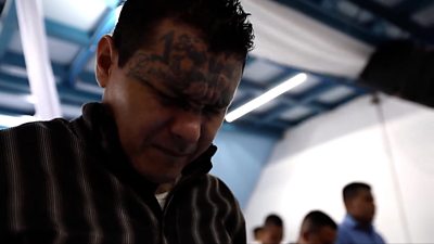 A man with face tattoos praying