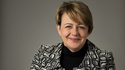 A woman in a black and white patterned jacket