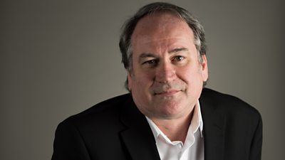 A man in a dark suit and white shirt