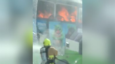Firefighter tackles bus fire.