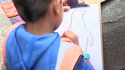 A child drawing a penguin