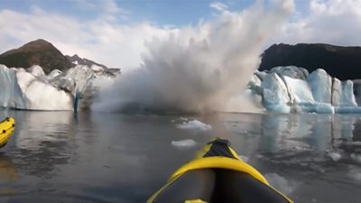 Glacier collapses in front in kayakers