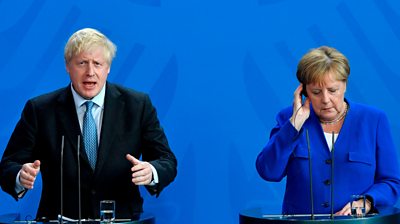 British Prime Minister Boris Johnson and German Chancellor Angela Merkel (R) speak to journalists at the Chancellery