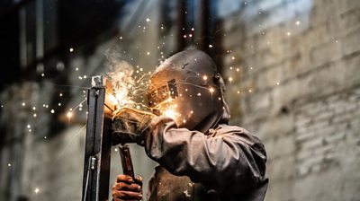 Industrial worker welding steel