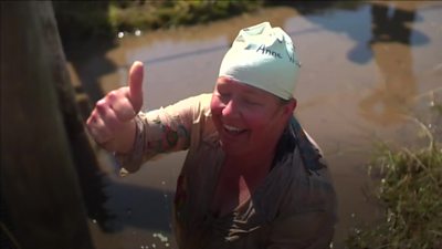 A Bog swimmer gives a smile and a thumbs up