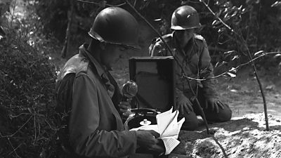 Correspondents with ˿ Midget Recorders make a report in the field with tin hats on