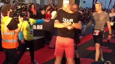 Gareth Thomas is hugged by husband Stephen after finishing the Ironman triathlon in Tenby, Pembrokeshire