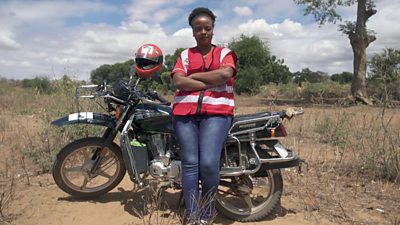 Cecilia Wairimu Ngari standing by her motorbike