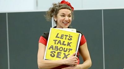 Woman holding a sign saying "Let's talk about sex"